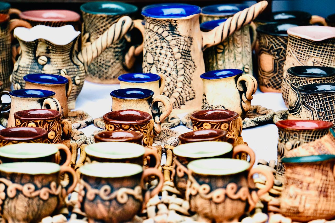 Mesa de feria con tejidos, cestería y cerámica artesanal de distintas regiones argentinas.